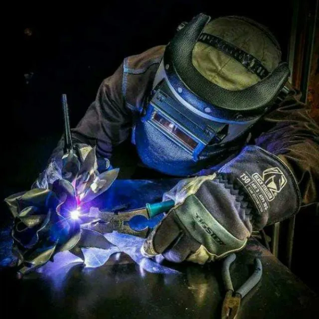 Soldador trabalhando com máscara e tocha de solda